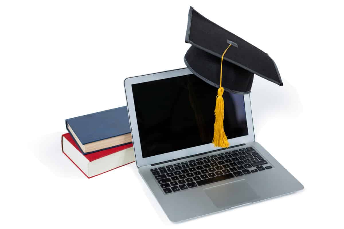 Laptop with graduation cap and books