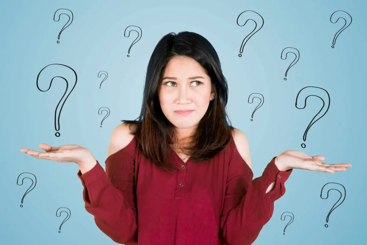 Picture of young Asian woman looks confused while standing with question marks