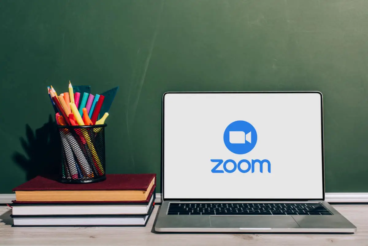 Zoom on Computer Screen next to Books and school supplies
